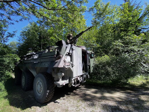 Ein untergezogener Truppentransportpanzer (TPz Fuchs). Ein Soldat sichert am Maschinengewehr.