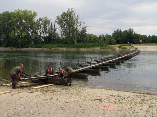 Immer mehr der einzelnen Pontonteile, die mit einer Spurtafel und Geländerstangen zusammengebaut wurden, werden zu Wasser gelassen.